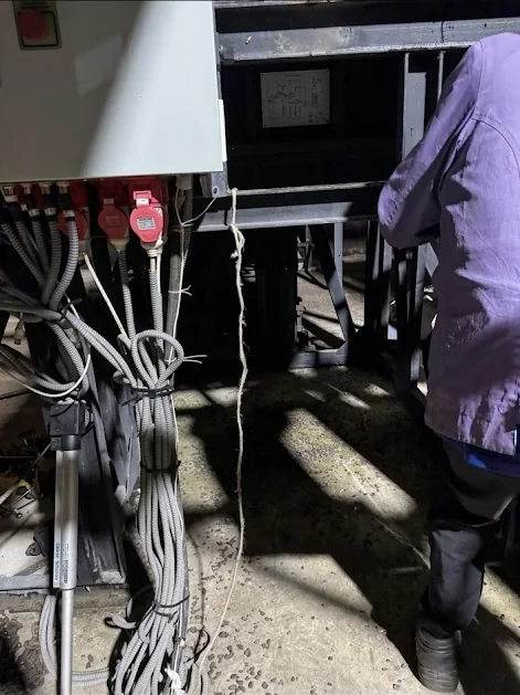 A team member works beside biochar production equipment inside the plant.